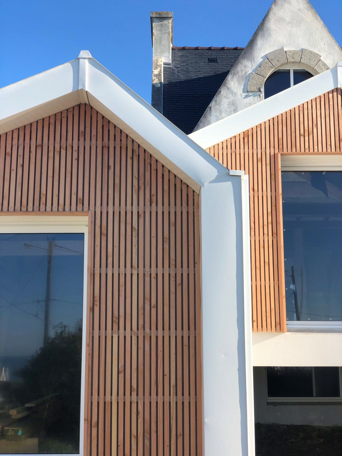 Extension en zinc et en bois d'une maison au bord de mer. menuiseries blanches
