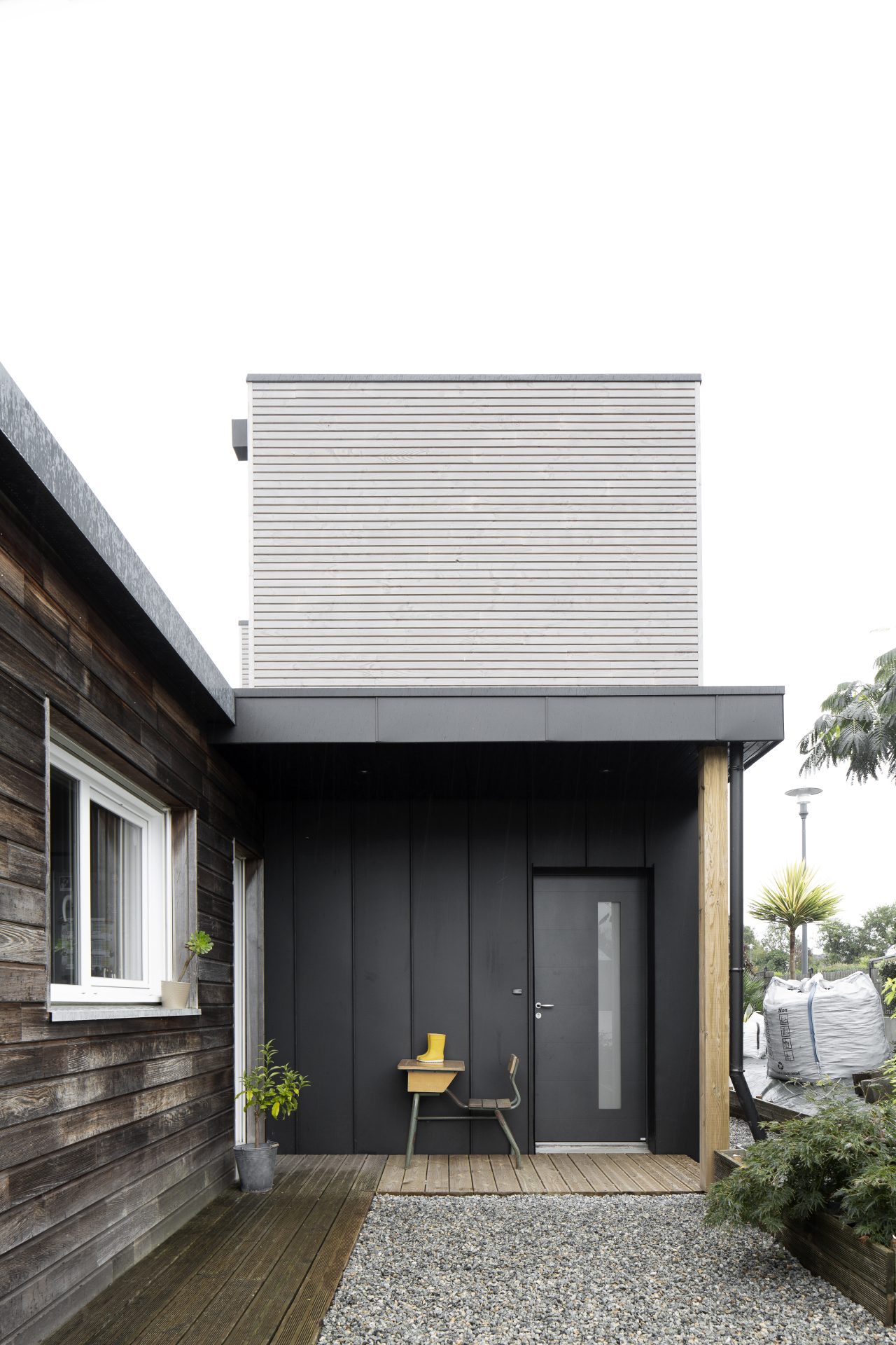 Extension d’une maison Bois et zinc toiture plate Casquette en aluminium noir