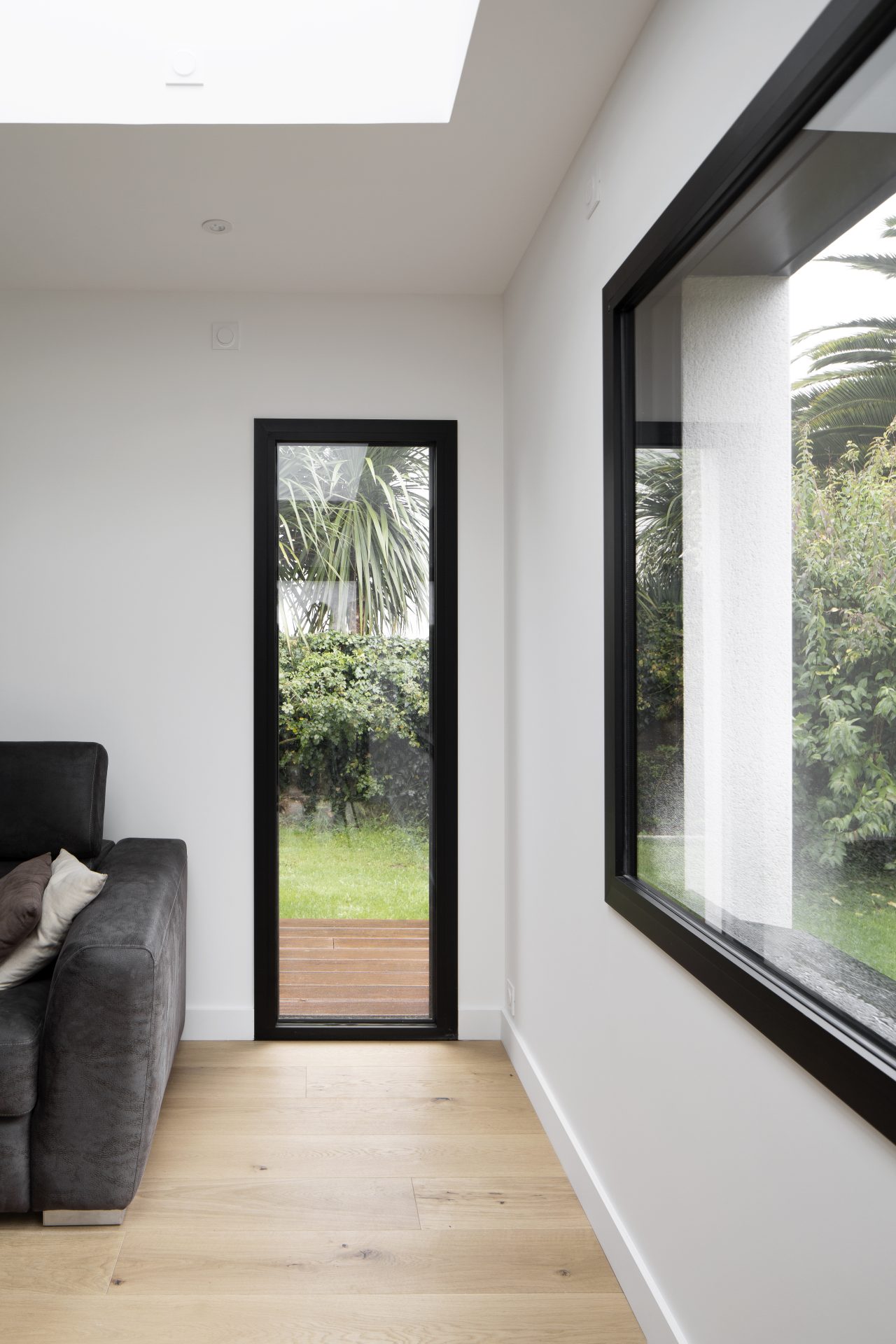 Extension d'une maison Baie vitrée prolongeant l'espace intérieur vers extérieur Puit de lumière Parquet sol